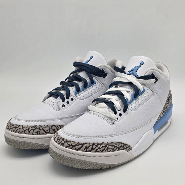 White sneakers with blue laces on a light gray background