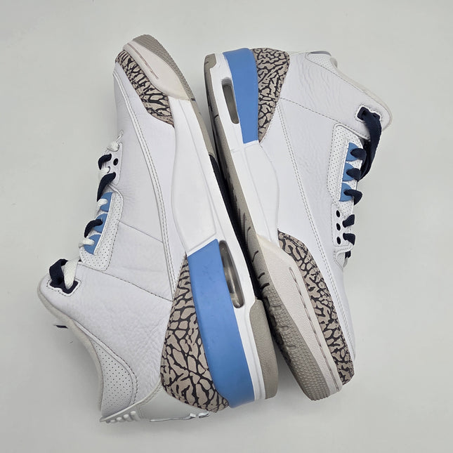 Pair of white sneakers with blue accents on a light gray background