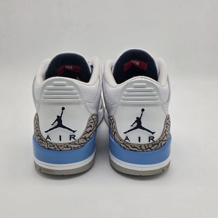 Pair of white sneakers with blue accents and a logo on a light gray background