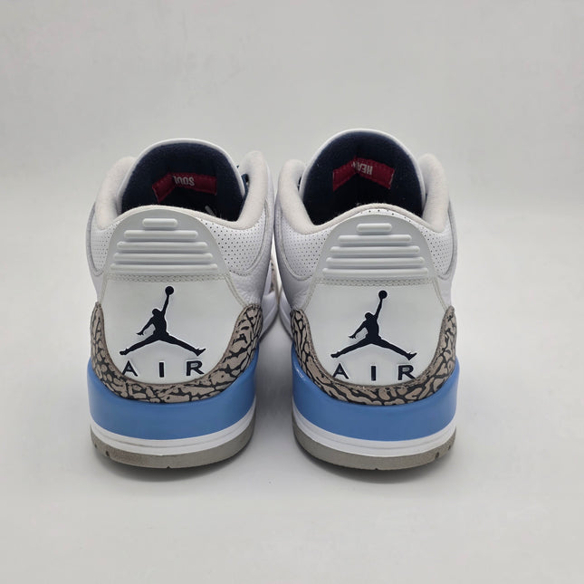 Pair of white sneakers with blue accents and a logo on a light gray background